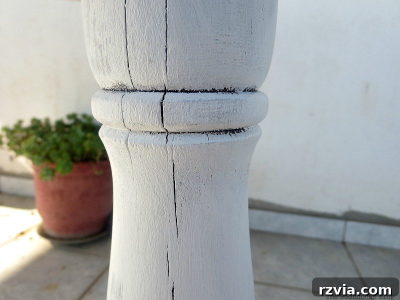 Upcycled Elegance: Crafting a Pallet and Salvaged Wood Table 13 The reclaimed table legs painted white, creating a beautiful contrast with the dark pallet top while still allowing some original cracks and texture to show through. www.theboondocksblog.com