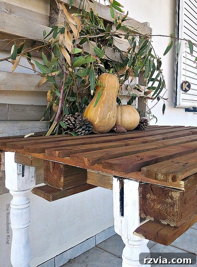 Upcycled Elegance: Crafting a Pallet and Salvaged Wood Table 21 The finished DIY pallet table adorned with decorative pumpkins, perfect for autumn displays and outdoor seasonal decor. www.theboondocksblog.com