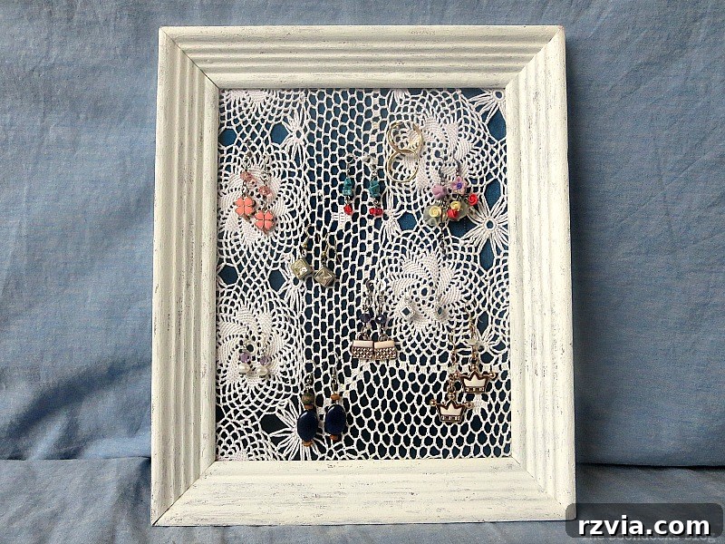 DIY Earring Storage Made Simple 10 The finished DIY earring organizer, showcasing its elegant frame, blue satin fabric, and white doily, with earrings beautifully displayed.