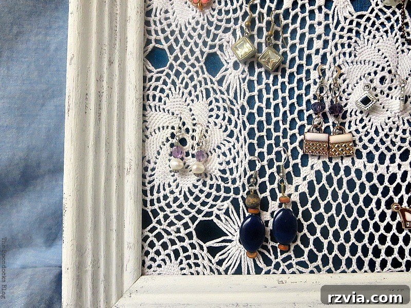 DIY Earring Storage Made Simple 11 A close-up shot focusing on the top portion of the earring organizer, highlighting the rustic texture of the frame and a selection of earrings.