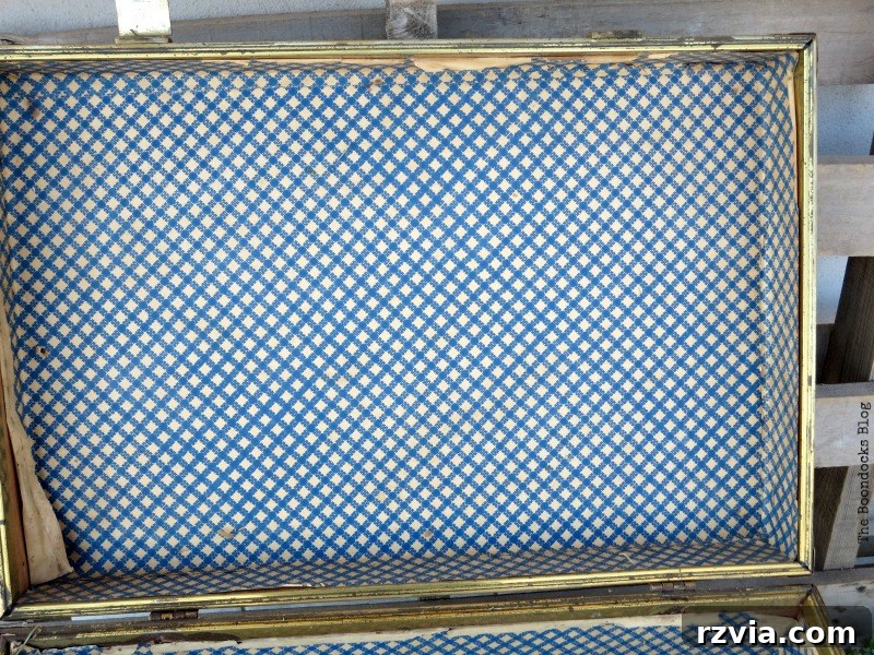 What Stories Does the Vintage Suitcase Tell 3 The inside of the vintage suitcase before restoration, showing wear and tear