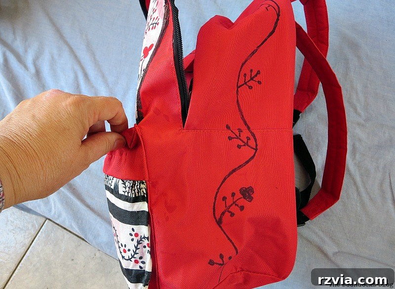 From Fabric Scraps to Adventure Packs 13 Drawing a floral design on the side of the backpack to mimic the fabric pattern, adding personalized interest.