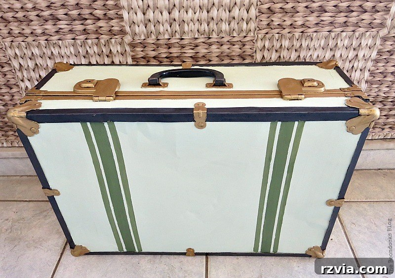 Breathing New Life into Old Luggage 11 The completely restored vintage suitcase, now painted in soft olive green, burnished gold, and black, proudly displayed in its finished state.