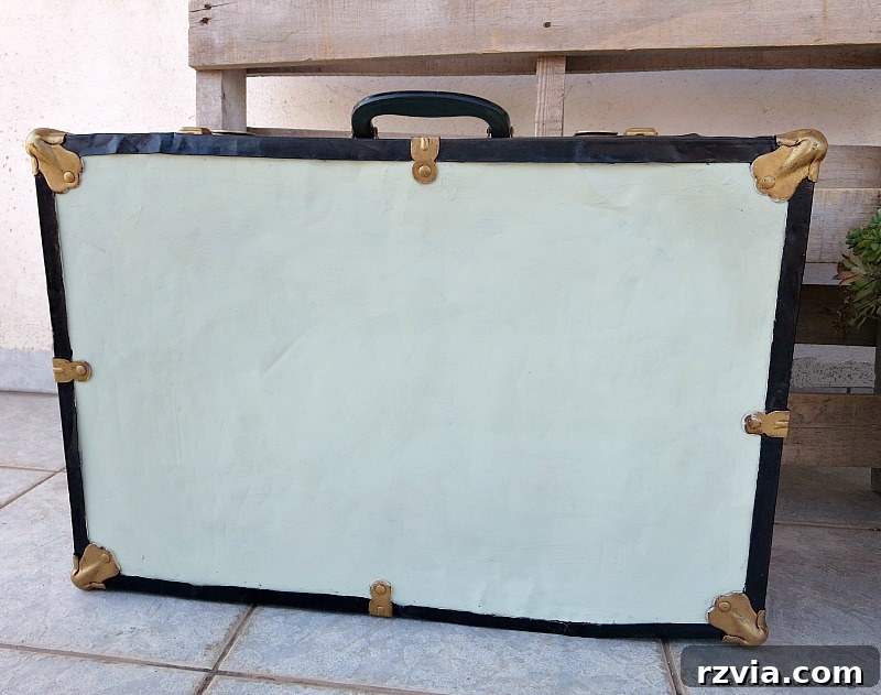 Breathing New Life into Old Luggage 14 The underside of the vintage suitcase, simply painted with the soft olive green chalk paint, reflecting a practical design choice.