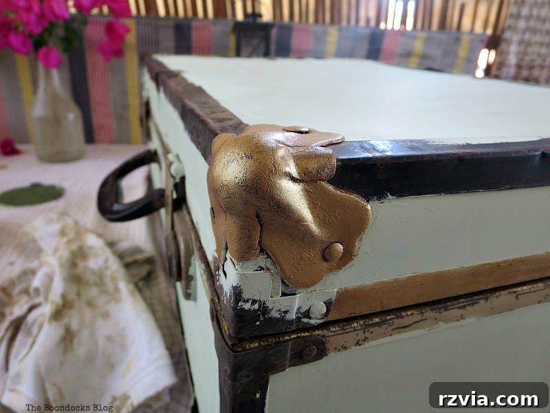 Breathing New Life into Old Luggage 5 Carefully applying burnished brass metallic lustre to the corner bumpers of the vintage suitcase, creating an elegant metallic accent.