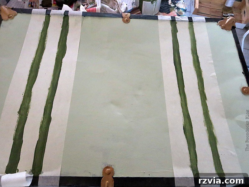 Breathing New Life into Old Luggage 9 Carefully painting soft olive green stripes on the top of the suitcase, creating the illusion of classic vintage straps.