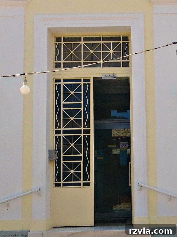 Brightly opened yellow metal door, inviting and cheerful, capturing the vibrant spirit of Greece, shared on www.theboondocksblog.com.