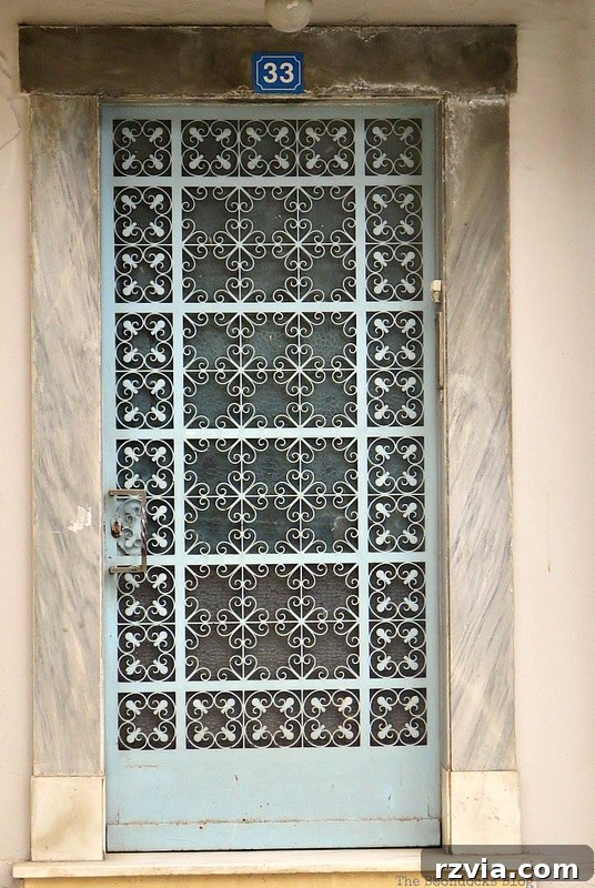 Serene light blue metal door, contributing to the picturesque street scenes of Greece, from www.theboondocksblog.com's collection.