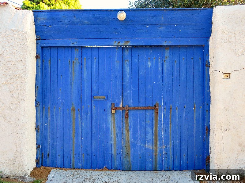 Charming blue wooden gate, a typical entrance to a Greek courtyard or garden, highlighted on www.theboondocksblog.com.