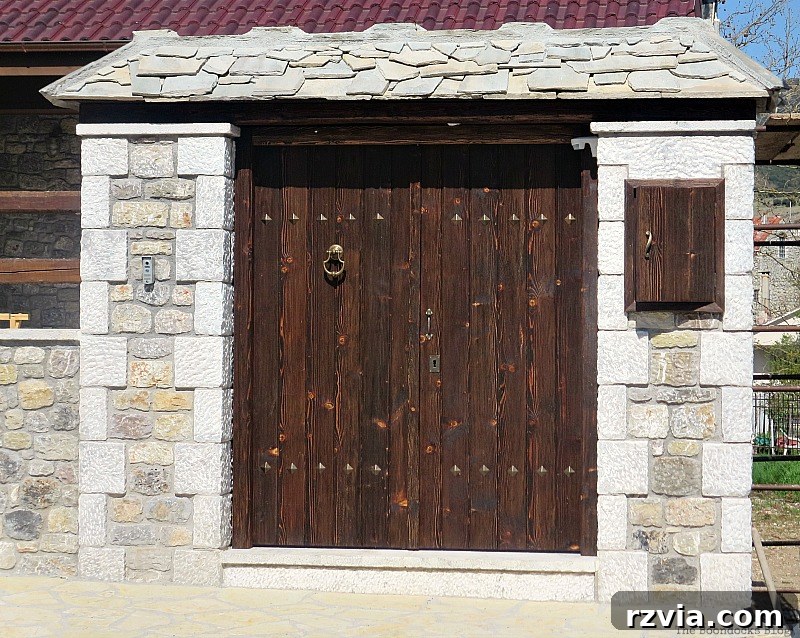 Well-preserved wooden gate, showcasing meticulous care and traditional carpentry in Greece, featured by www.theboondocksblog.com.