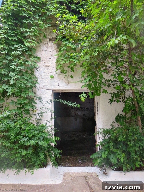 An intriguing opening where the door is missing, inviting contemplation of what lies beyond in a Greek structure, presented by www.theboondocksblog.com.