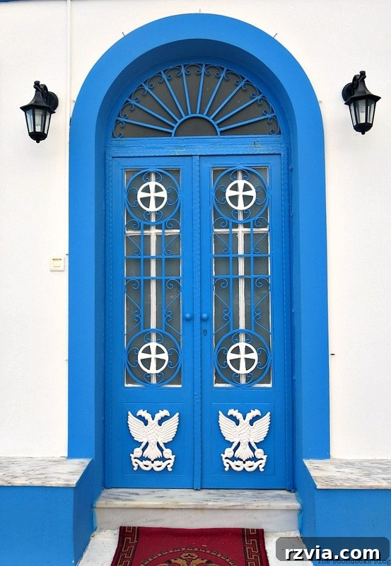 Vibrant blue metal church door, a striking example of modern religious architecture in Greece, shared by www.theboondocksblog.com.