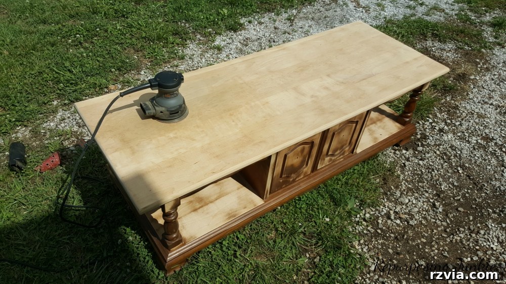 From Curb to Chic: Coffee Table's Gorgeous New Look 4 Detailed image of the coffee table being sanded, a vital step in its repurposing makeover shared by Repurposing Junkie.