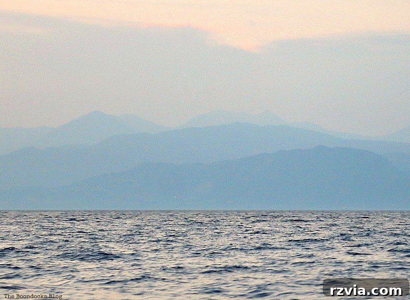 Layers of mountain silhouettes, dramatically outlined against the sunset