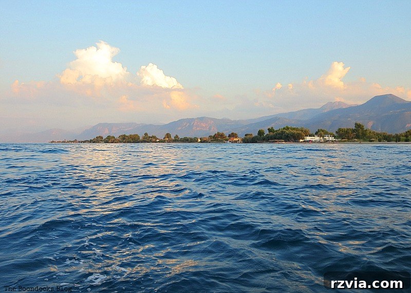 Panoramic view of the coast from the boat, with aqua clouds overhead