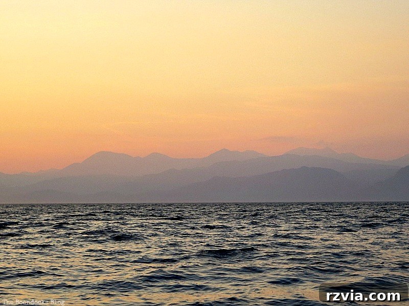 Mountain silhouettes against the sunset sky, a dramatic backdrop