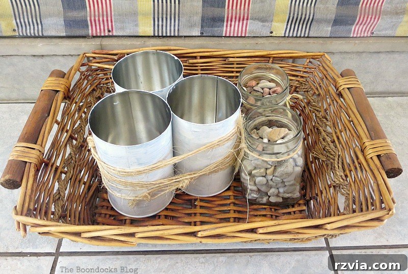 A decorative basket creatively filled with various cans and jars, showcasing a resourceful and charming storage solution. Basket with Cans and Jars, Part 1 www.theboondocksblog.com