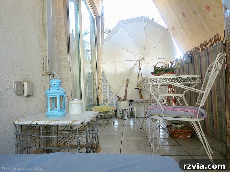 A sun-drenched corner of the balcony with elegant glass doors, offering a bright view and a sense of open-air living. The Corner with the Glass Doors, Part 1 www.theboondocksblog.com