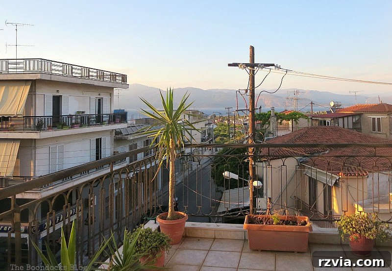 A picturesque view of the bay and mountains, with some plants in the foreground, emphasizing the stunning scenery from the balcony. Dead Plants and a View, Part 1 www.theboondocksblog.com