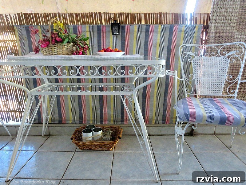 A white metal table with chairs covered in fabric matching the privacy screens, creating a cohesive and stylish outdoor dining area. Screen and Matching Chairs, Part 1 www.theboondocksblog.com
