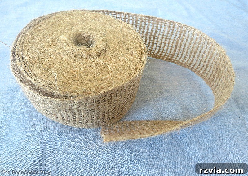 Burlap ribbon being wrapped around the repurposed tin can, adding a rustic decorative element to the DIY vase.