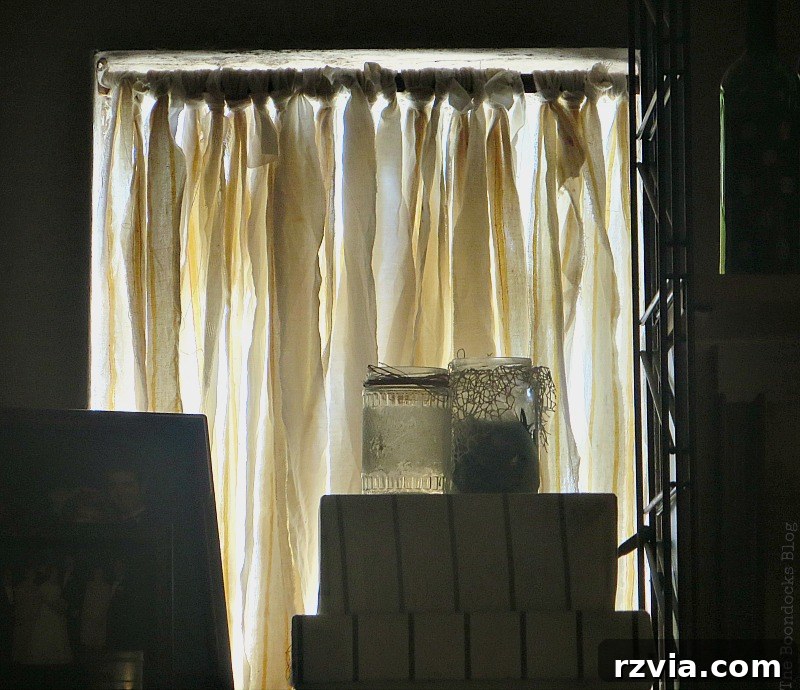 The fabric-tied wood trim wedged into the glass block window opening, filtering light.