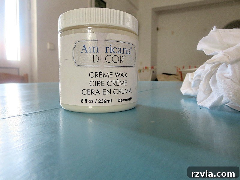 Applying Americana Decor Creme Wax to the freshly painted blue tabletop, adding protection and a beautiful finish to the Greek Beach Table, a key step in this Int'l Bloggers Club Challenge project by theboodocksblog.com