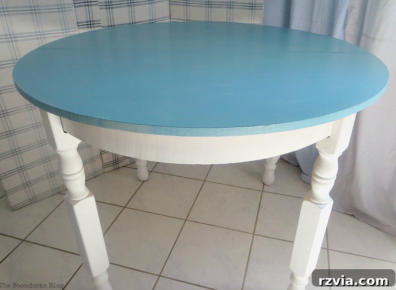 The finished Greek Beach Table, showcasing its beautiful blue top and white legs, ready to bring coastal charm to any home. A successful Int'l Bloggers Club Challenge project by theboodocksblog.com