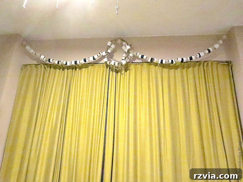 Another nighttime perspective of the paper roll decor, subtly revealing the wall color which shifts into an unexpected 'pucky pink' hue under the artificial light, highlighting a common home painting dilemma.