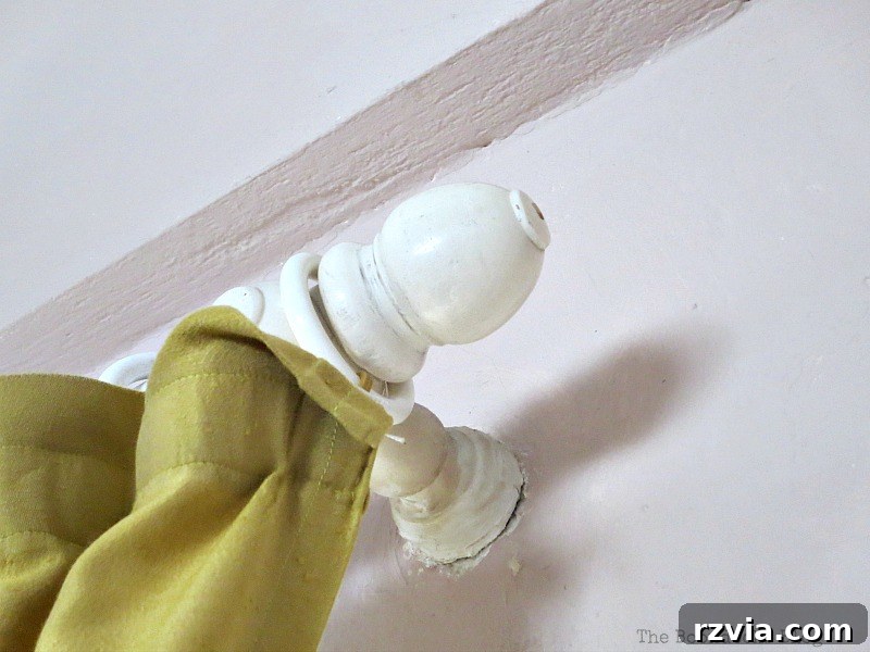 Close-up photograph of an old, unused curtain rod bracket, prominently fixed to the wall above a sliding door, representing a challenging aesthetic problem in the living room decor. This image captures the visual annoyance that inspired the DIY solution.