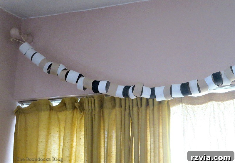 The fully assembled and densely packed paper roll garland, gracefully hung from the curtain brackets, now effectively covering them and creating a cohesive decorative element across the sliding door. This image shows the successful concealment.