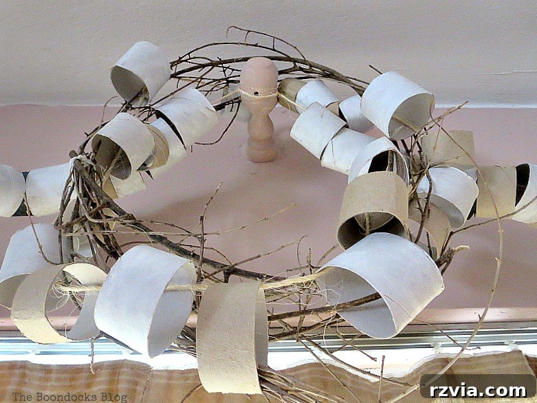 A detailed close-up shot of the rustic wreath, emphasizing the intricate arrangement and varied textures of the repurposed paper rolls, natural twigs, and twine. This image highlights the artisanal quality and unique design elements.