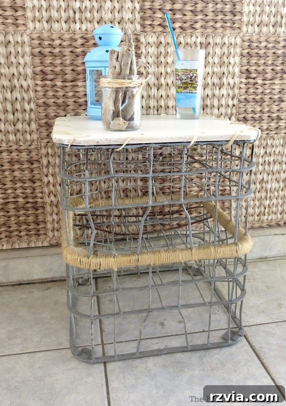 Beyond the Box: Milk Crate Table Reinvention 2 The finished wire milk crate table with a drinking cup, lantern and driftwood in a jar placed on top. The table showcases a fresh, clean look on a sunny balcony, embodying renewed outdoor style.