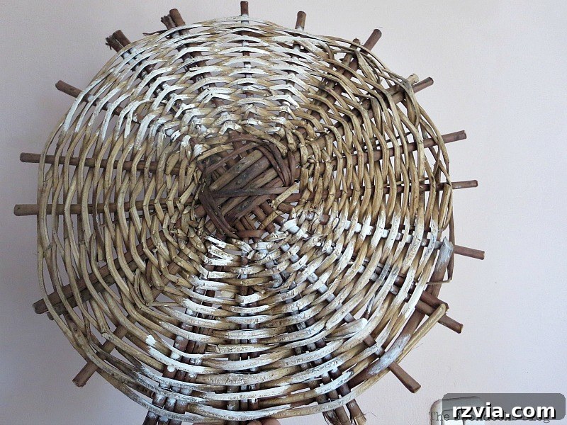 Applying white paint to the wicker basket bottom for a shabby chic effect.