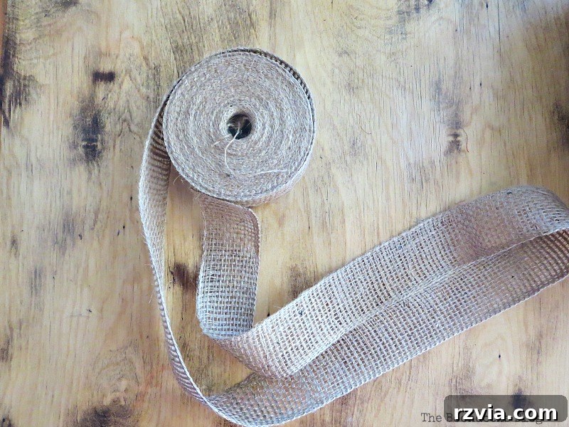 A large roll of natural burlap ribbon, ready for crafting.
