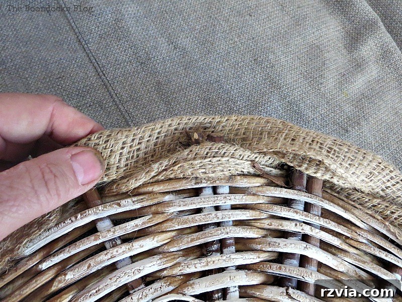 Shabby Chic Wicker Basket Revival 8 Threading folded burlap ribbon through the edge of the wicker basket bottom.