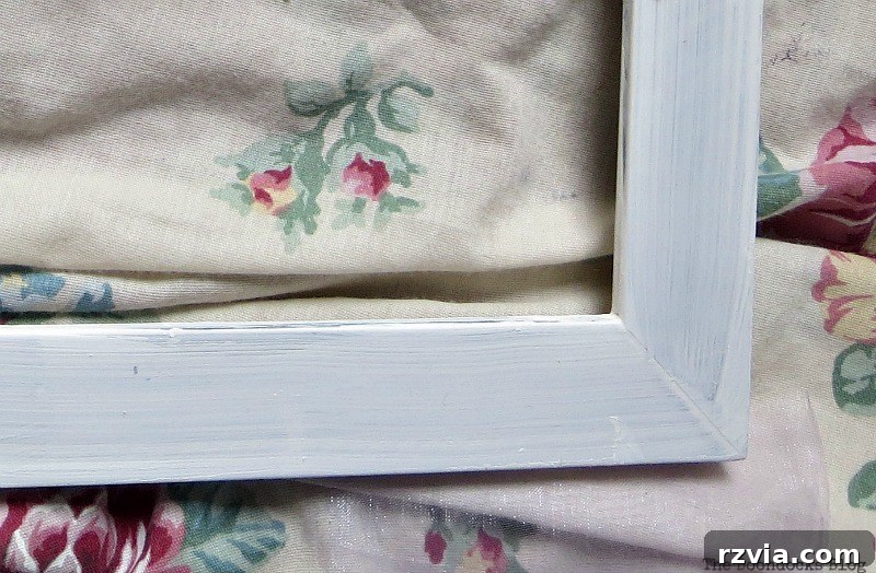 Daughter painting the old blue frame white using chalk paint, for The Stars and Moon project on www.theboondocksblog.com