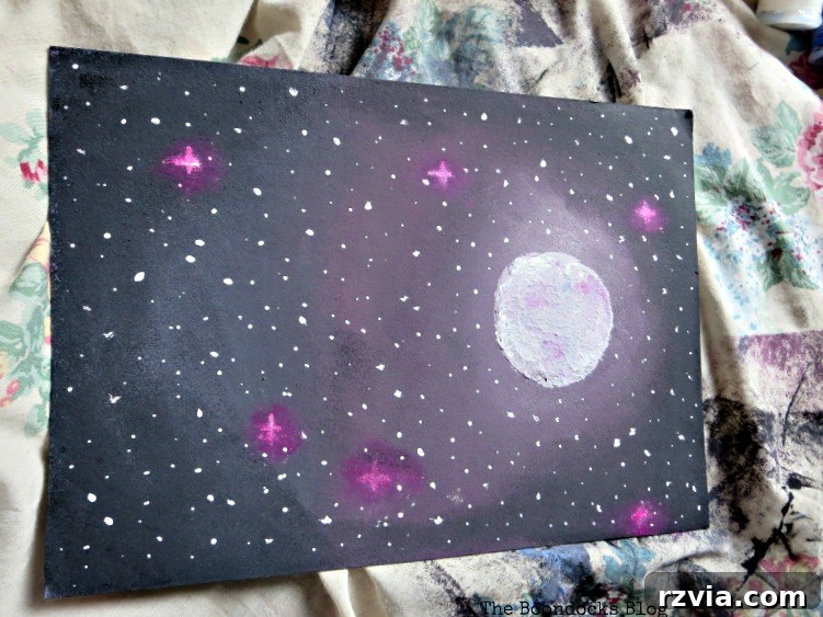 A stunning galaxy painting of stars and the moon, ready to be inserted into the upcycled frame, from www.theboondocksblog.com