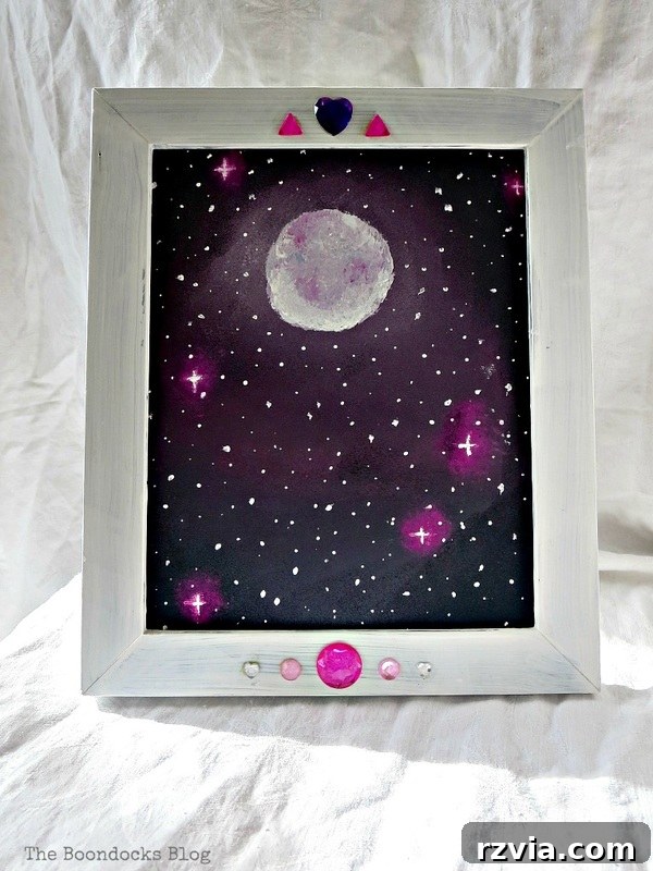 The finished picture frame with galaxy canvas, beautifully wrapped and ready to be given as a gift, from The Stars and Moon project on www.theboondocksblog.com