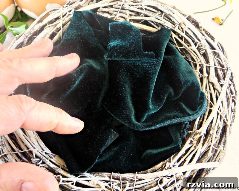 Soft velvet fabric carefully arranged inside the white wreath, simulating a cozy nest interior