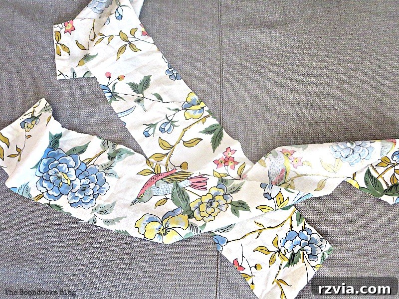 Close-up of fabric strips in spring colors and patterns, including repurposed material, being used to wrap a wreath base for a DIY project.