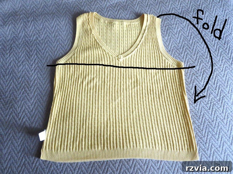 Quick & Cozy: DIY Sweater Pillows 4 Close-up view of a hand sewing a running stitch across the arm opening of a sweater vest, the first step in making an easy DIY sweater pillow.