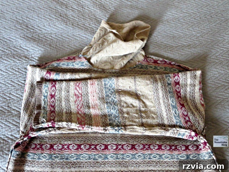 Quick & Cozy: DIY Sweater Pillows 7 A sweater, turned inside out, with its sleeves neatly folded inward towards the body, preparing it for stuffing to create a DIY pillow.