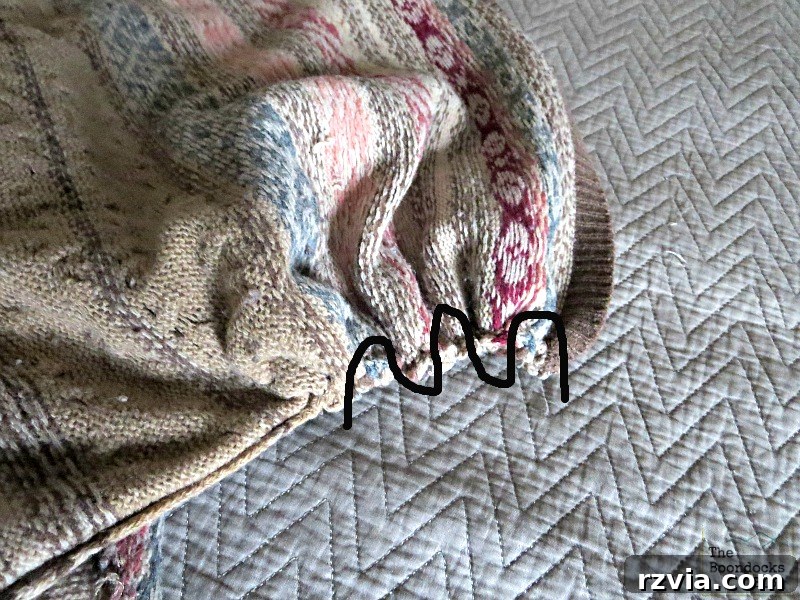 Quick & Cozy: DIY Sweater Pillows 9 Close-up of a gathering stitch being applied to the ends of a sweater, creating a bunched effect for the side of the DIY pillow.