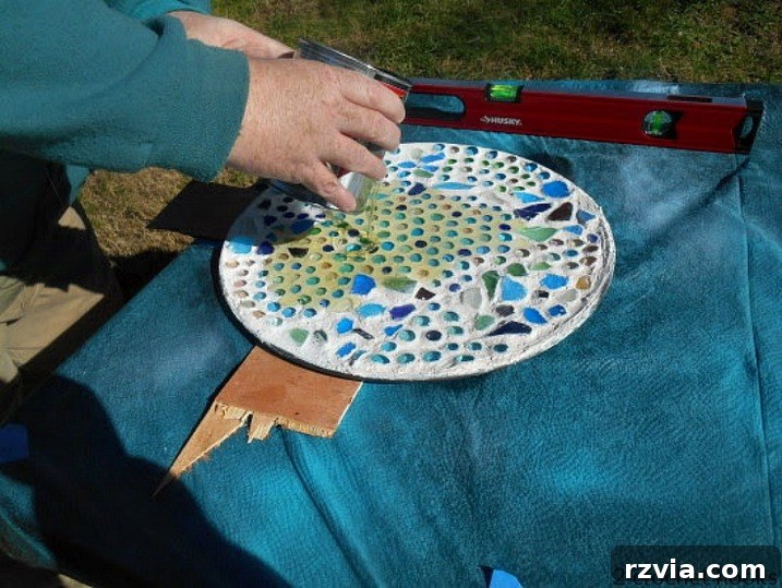 Craft Your Own Sea Glass Mosaic Table 10 A hand applying a layer of polyurethane sealant to the top of the newly finished sea glass mosaic tabletop, aiming to provide a durable, clear finish.