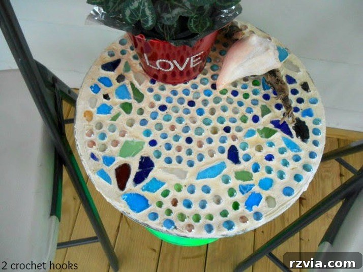 Craft Your Own Sea Glass Mosaic Table 13 A vibrant aerial view of the finished sea glass mosaic table top, highlighting the intricate arrangement of colorful glass and marbles, ready for display.