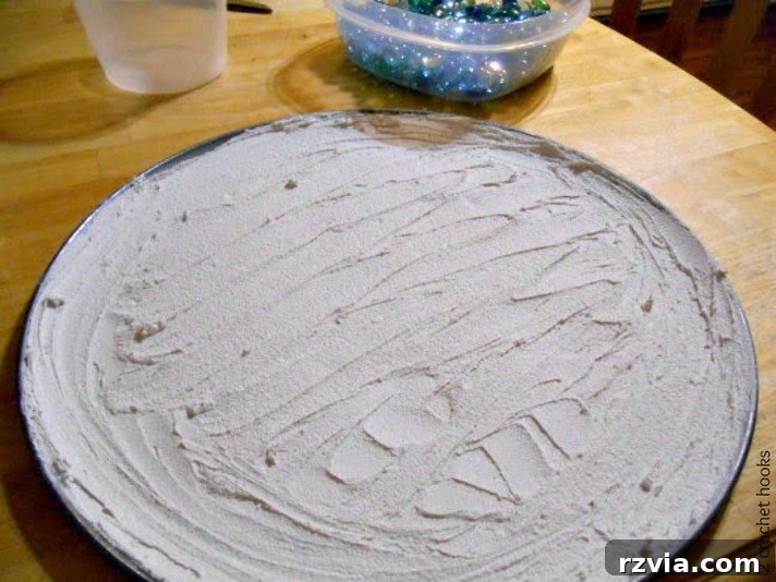 Craft Your Own Sea Glass Mosaic Table 5 A used pizza pan being prepped, slathered with a thick, even layer of grout, ready to form the base of the mosaic tabletop.