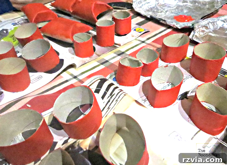 Applying bright red paint to toilet paper rolls, preparing them for the heart craft project.