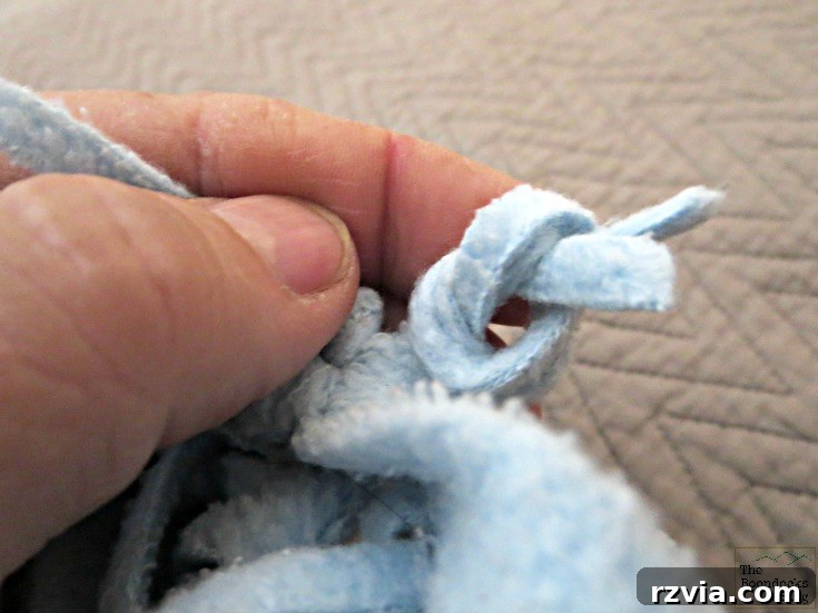 Effortless Fleece Pillow 5 Scarf folded in half, preparing to tie fringes for DIY pillow