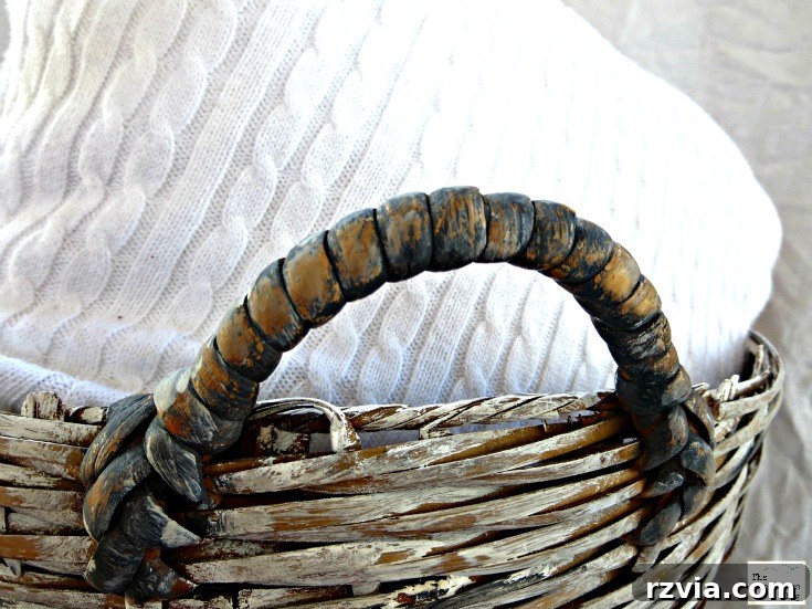 Close-up detail shot of the beautifully distressed handle on the refurbished wicker basket, showcasing the aged effect